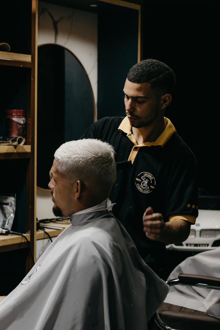 Barber skillfully cuts hair in a modern barbershop setting, focusing on style and precision.